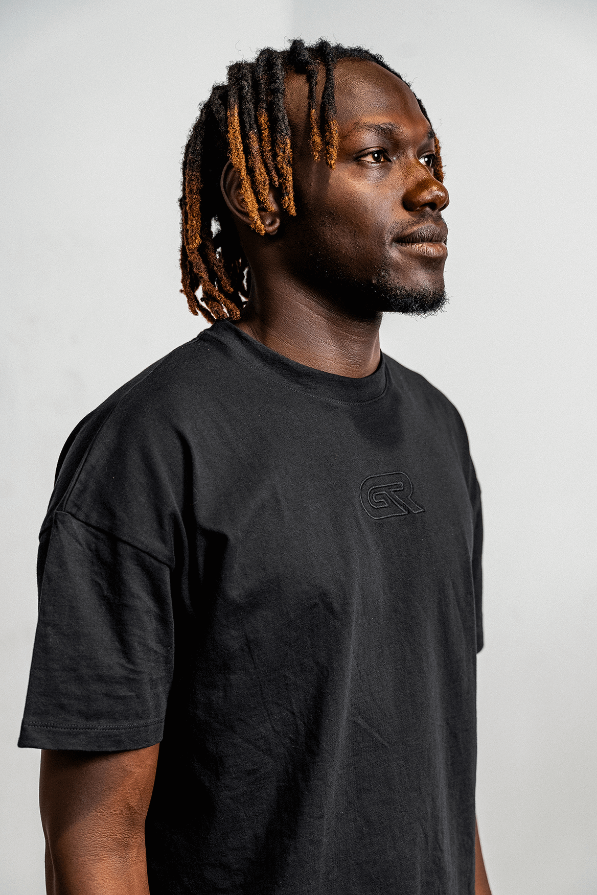 Man wearing a black t-shirt with a logo on a white background